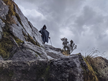 Ein Mensch steht auf einem Berg Massiv und schaut hinunter 